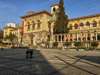 People on street amidst buildings in city