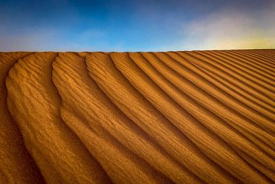 Close-up of sand dune in desert against sky