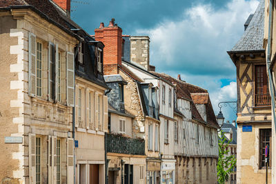 Low angle view of buildings in town against sky