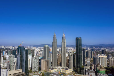 Modern buildings in city against blue sky