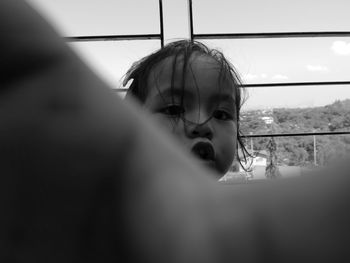 Portrait of girl looking through window