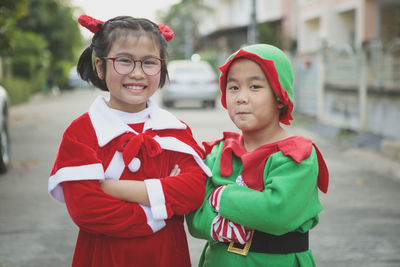 Asian girl and boy wearing santa claus suit playing with happiness outdoor