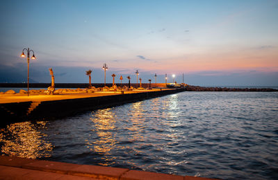 Pier over sea against sky during sunset