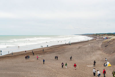 People on beach against sky