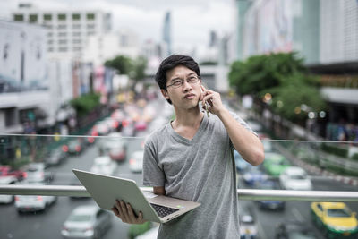 Young man using mobile phone in city