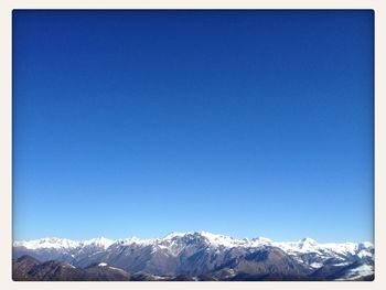 Scenic view of snow covered mountains against clear sky