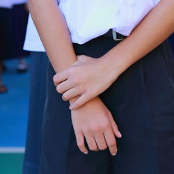 Midsection of schoolboy standing outdoors