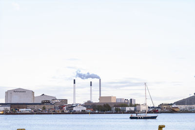 Smoke emitting from factory against sky