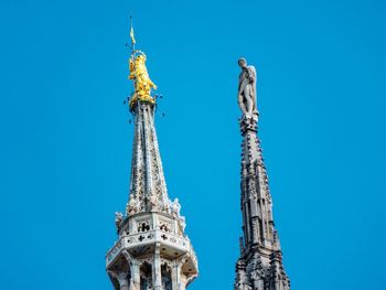 Low angle view of towers against clear blue sky