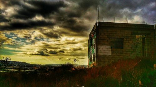 Built structure on beach against dramatic sky