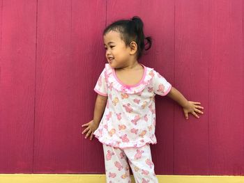 Cute girl standing against wall