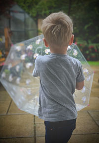 Rear view of boy standing outdoors