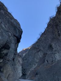 Low angle view of rock formation against clear blue sky