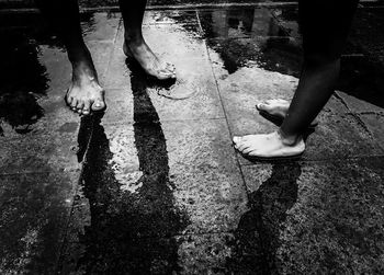 Low section of people standing on wet puddle