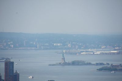 High angle view of buildings by sea against clear sky