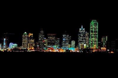 Illuminated buildings against sky at night