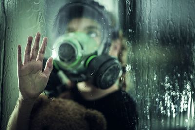 Midsection of woman swimming in sea seen through glass window