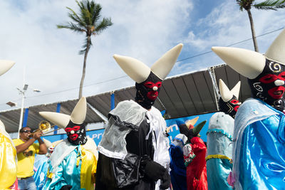 Group of masked and costumed people parade in fuzue, pre-carnival in salvador, bahia, brazil.