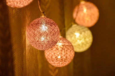 Low angle view of illuminated pendant lights hanging from ceiling