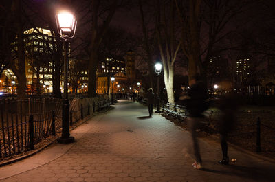 Illuminated street lights in city at night