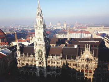 Aerial view of buildings in city against sky