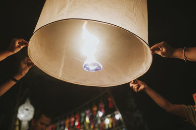 Low angle view of hand holding illuminated light