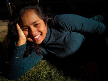 Portrait of smiling woman lying on grass