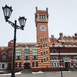 Low angle view of clock tower amidst buildings against sky