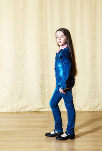 Portrait of cute girl standing on hardwood floor