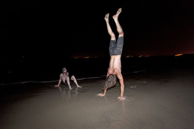 Friends playing on a beach at night