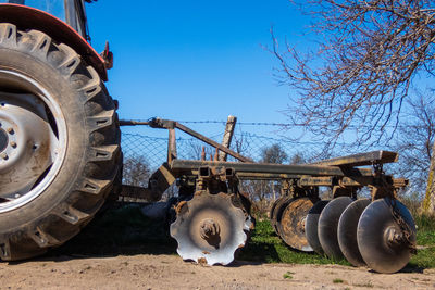 Close-up of machinery on field against clear blue sky