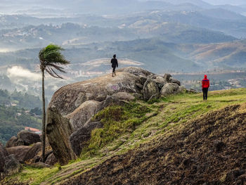 Rear view of man on rock against mountains