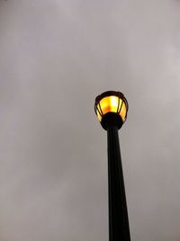 Low angle view of illuminated street light against sky