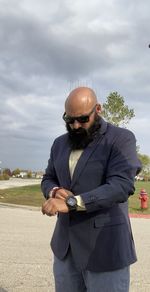 Man wearing sunglasses standing against the sky