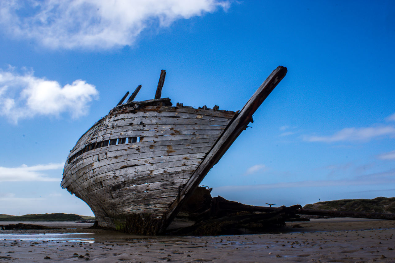 sky, cloud - sky, water, decline, shipwreck, land, damaged, deterioration, obsolete, beach, nature, abandoned, ship, sea, nautical vessel, run-down, no people, day, transportation, outdoors, ruined, low tide