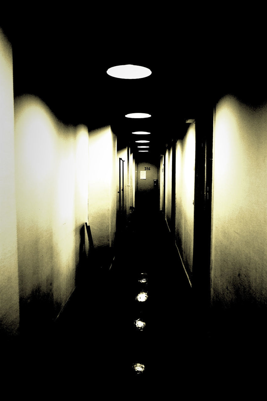 indoors, illuminated, the way forward, dark, corridor, tunnel, diminishing perspective, lighting equipment, empty, light - natural phenomenon, wall - building feature, built structure, night, vanishing point, architecture, wall, copy space, absence, no people, long