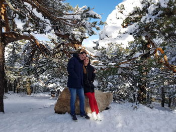 Full length of woman standing on snow covered trees