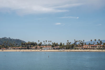 Scenic view of sea by town against sky