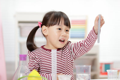 Young girl playing science experiment at home 