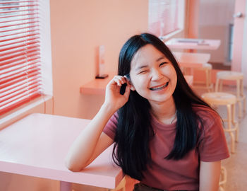 Portrait of smiling teenage girl at table