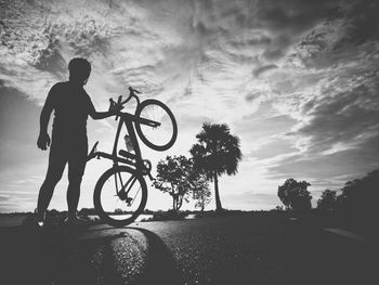 Silhouette of man with bicycle