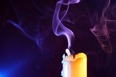Close-up of emitting smoke against black background