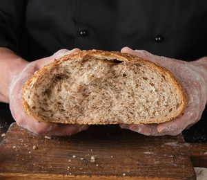 Close-up of hand holding bread on table