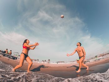 Young couple playing on beach