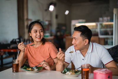 Portrait of smiling friends sitting at restaurant