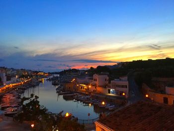 High angle view of illuminated town against sky at sunset