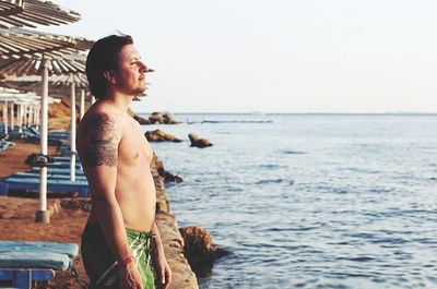 Man looking at sea shore against sky