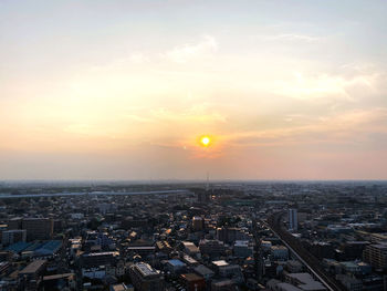 High angle view of city against cloudy sky during sunset