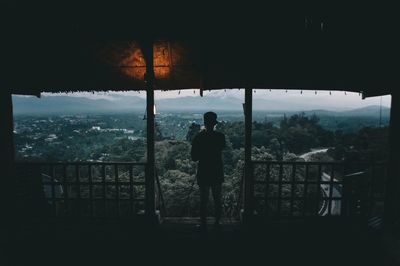 Rear view of silhouette man standing at observation point