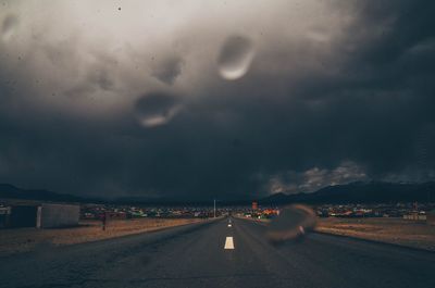 Cars on road against sky during rainy season